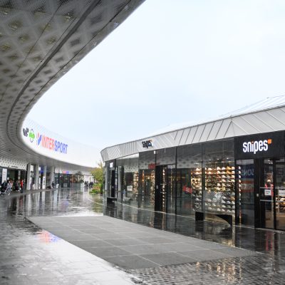 À proximité d'Angers, ce centre commercial abrite une large gamme de boutiques et de services. A l'intérieur du complexe, les points de vente en forme de ""Galets"" sont constitués d'une structure mixte bois / métal représentants des formes les plus futuristes.