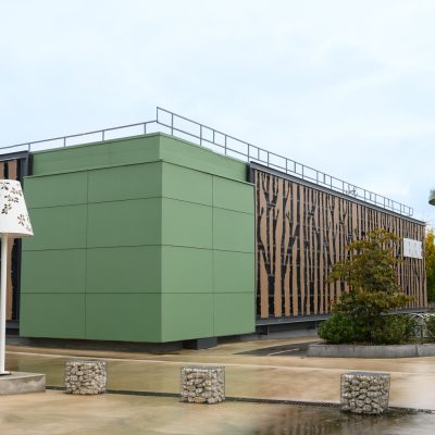 Situé à Pontault-Combault, ce centre commercial se veut moderne et écologique. Le bardage en stratifié haute pression sublime l'identité du site, avec une finition immitation bois et un découpage en forme de troncs d'arbres. Les parasols, eux aussi, rappellent la nature avec les découpes laser en forme de feuille. Un travail de précision pour un rendu de qualité.
