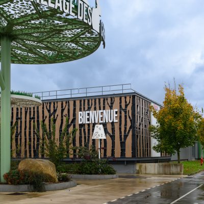 Situé à Pontault-Combault, ce centre commercial se veut moderne et écologique. Le bardage en stratifié haute pression sublime l'identité du site, avec une finition immitation bois et un découpage en forme de troncs d'arbres. Les parasols, eux aussi, rappellent la nature avec les découpes laser en forme de feuille. Un travail de précision pour un rendu de qualité.