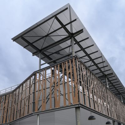 Situé à Pontault-Combault, ce centre commercial se veut moderne et écologique. Le bardage en stratifié haute pression sublime l'identité du site, avec une finition immitation bois et un découpage en forme de troncs d'arbres. Les parasols, eux aussi, rappellent la nature avec les découpes laser en forme de feuille. Un travail de précision pour un rendu de qualité.