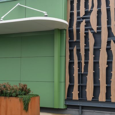 Situé à Pontault-Combault, ce centre commercial se veut moderne et écologique. Le bardage en stratifié haute pression sublime l'identité du site, avec une finition immitation bois et un découpage en forme de troncs d'arbres. Les parasols, eux aussi, rappellent la nature avec les découpes laser en forme de feuille. Un travail de précision pour un rendu de qualité.