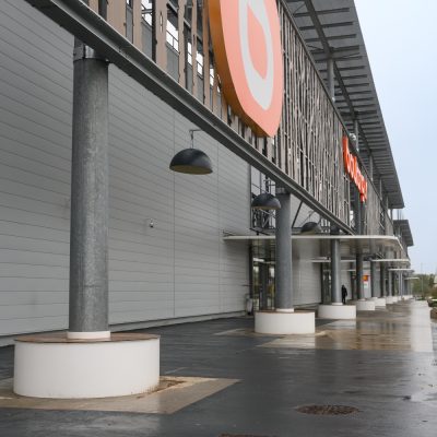 Situé à Pontault-Combault, ce centre commercial se veut moderne et écologique. Le bardage en stratifié haute pression sublime l'identité du site, avec une finition immitation bois et un découpage en forme de troncs d'arbres. Les parasols, eux aussi, rappellent la nature avec les découpes laser en forme de feuille. Un travail de précision pour un rendu de qualité.