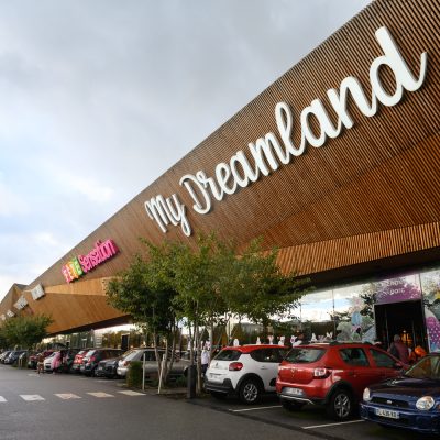 À Osny, ce centre commercial multi-enseignes est un centre de shopping, restauration et de loisirs. Parties vitrées, bardage en bois et en acier sont les éléments qui composent son habillage, montrant l'univers du possible, nottament avec le bardage en bois aux formes irrégulières.