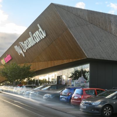 À Osny, ce centre commercial multi-enseignes est un centre de shopping, restauration et de loisirs. Parties vitrées, bardage en bois et en acier sont les éléments qui composent son habillage, montrant l'univers du possible, nottament avec le bardage en bois aux formes irrégulières.