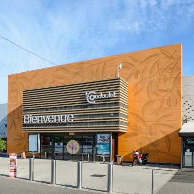 Ce centre commercial, situé à Orange, offre, en plus de son hypermarché carrefour,une variété de magasins et de restaurants pour tous les goûts. Les deux accès principaux sont vêtus d'un bardage orange perforé selon un plan précis afin d'en faire ressortir des formes de feuilles d'olivier.