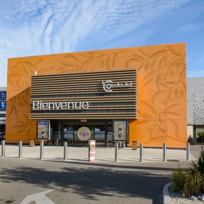 Ce centre commercial, situé à Orange, offre, en plus de son hypermarché carrefour,une variété de magasins et de restaurants pour tous les goûts. Les deux accès principaux sont vêtus d'un bardage orange perforé selon un plan précis afin d'en faire ressortir des formes de feuilles d'olivier.