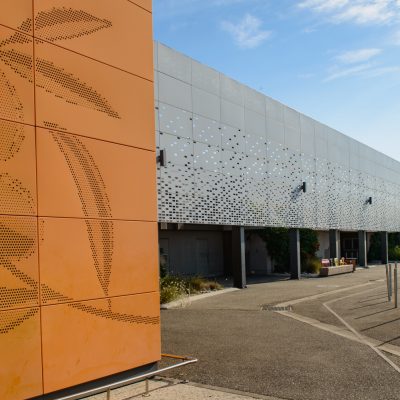 Ce centre commercial, situé à Orange, offre, en plus de son hypermarché carrefour,une variété de magasins et de restaurants pour tous les goûts. Les deux accès principaux sont vêtus d'un bardage orange perforé selon un plan précis afin d'en faire ressortir des formes de feuilles d'olivier.