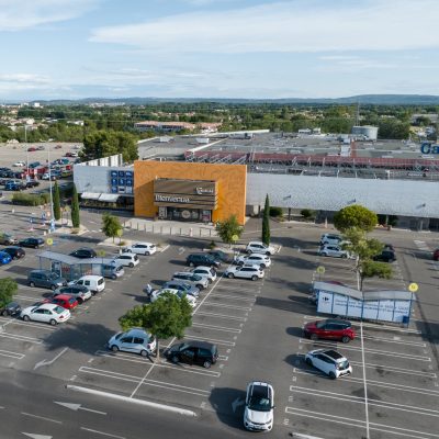 Ce centre commercial, situé à Orange, offre, en plus de son hypermarché carrefour,une variété de magasins et de restaurants pour tous les goûts. Les deux accès principaux sont vêtus d'un bardage orange perforé selon un plan précis afin d'en faire ressortir des formes de feuilles d'olivier.