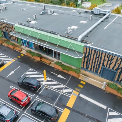 Situé à Pontault-Combault, ce centre commercial se veut moderne et écologique. Le bardage en stratifié haute pression sublime l'identité du site, avec une finition immitation bois et un découpage en forme de troncs d'arbres. Les parasols, eux aussi, rappellent la nature avec les découpes laser en forme de feuille. Un travail de précision pour un rendu de qualité.