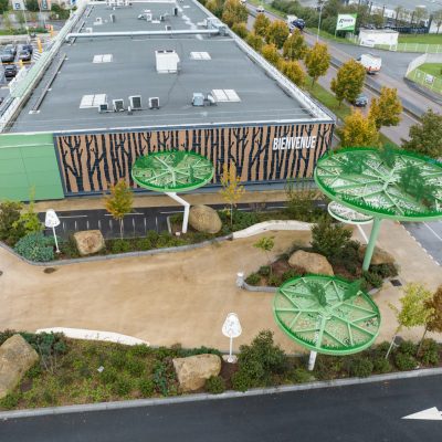 Situé à Pontault-Combault, ce centre commercial se veut moderne et écologique. Le bardage en stratifié haute pression sublime l'identité du site, avec une finition immitation bois et un découpage en forme de troncs d'arbres. Les parasols, eux aussi, rappellent la nature avec les découpes laser en forme de feuille. Un travail de précision pour un rendu de qualité.