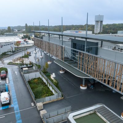 Situé à Pontault-Combault, ce centre commercial se veut moderne et écologique. Le bardage en stratifié haute pression sublime l'identité du site, avec une finition immitation bois et un découpage en forme de troncs d'arbres. Les parasols, eux aussi, rappellent la nature avec les découpes laser en forme de feuille. Un travail de précision pour un rendu de qualité.